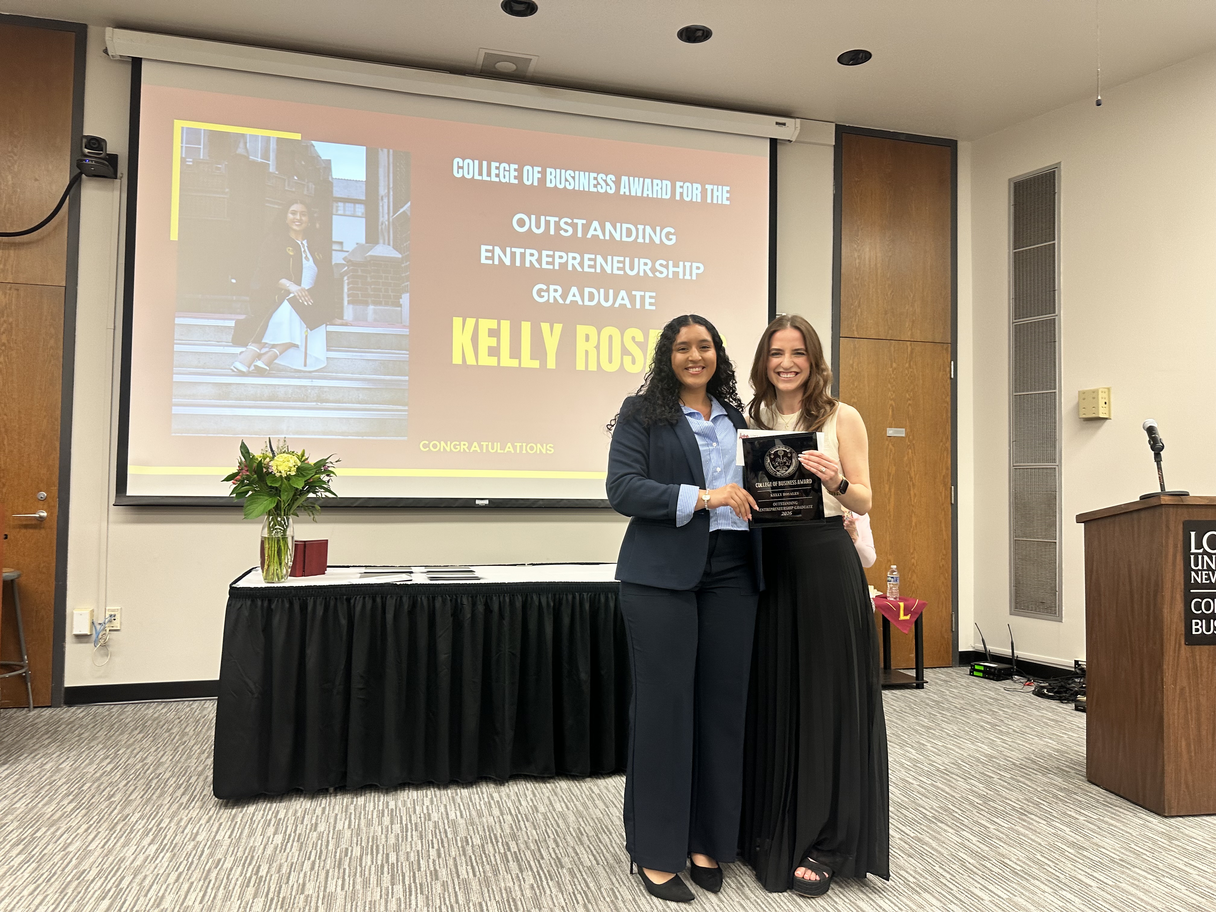 A Loyola University New Orleans CECD staff member presents Kelly Rosales with her award at the 2026 College of Business Awards Ceremony.