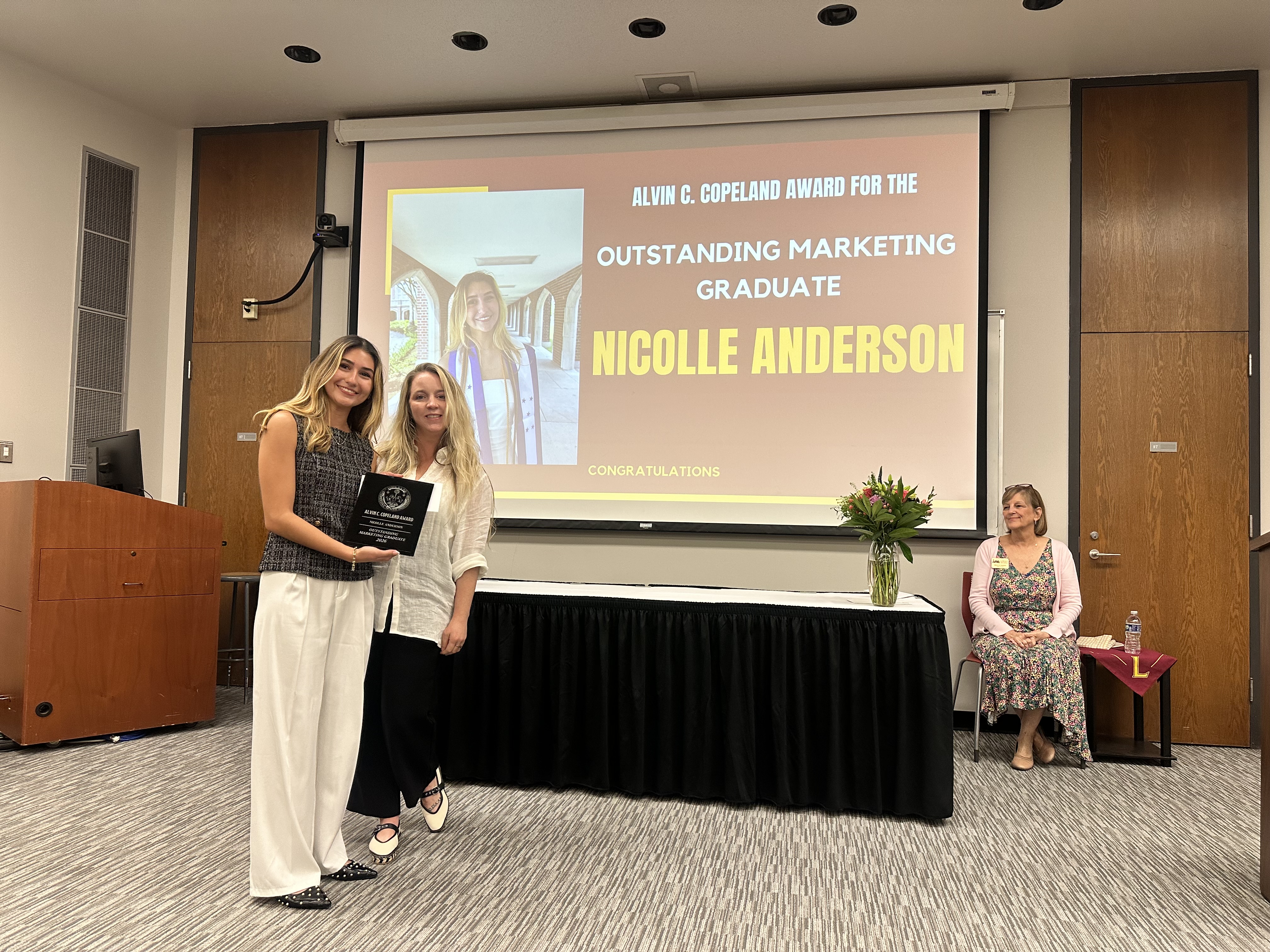 Loyola University New Orleans Lecturer in Marketing Liz Moser presents Nicolle Anderson with her Outstanding Marketing Graduate award at the 2026 College of Business Awards Ceremony.